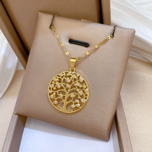 Macro detail of golden Tree of Life pendant with white zircon stones in jewelry gift box