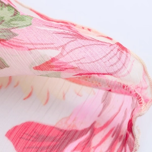 Close-up of floral print chiffon fabric with delicate rolled hem and pleated texture