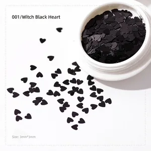 Macro shot of 3mm black heart-shaped sequins for nail art and DIY in a white container