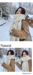 Detailed close-up of heavy white knitted scarf with fringe and a minimalist handmade tag
