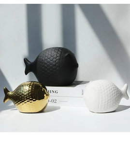 Detalle de peces decorativos de cerámica nórdica en negro, blanco y oro con textura escamosa