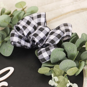 Couronne de Noël avec nœud à carreaux et eucalyptus pour décoration de porte d'entrée