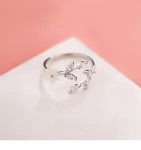 Macro detail of adjustable silver flower ring with white petals and clear zircon leaves
