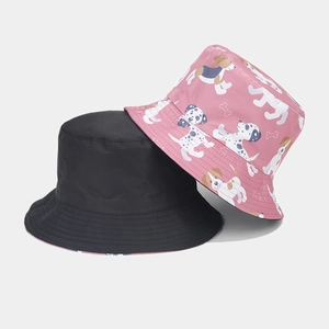 Detail of reversible bucket hat showing pink cartoon dog print and solid black fabric layers