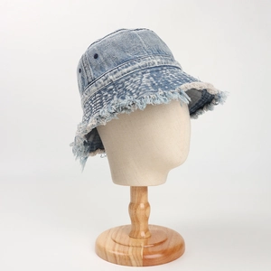 Dettaglio del cappello alla pescatora in denim blu lavato con bordi sfilacciati e stile retrò
