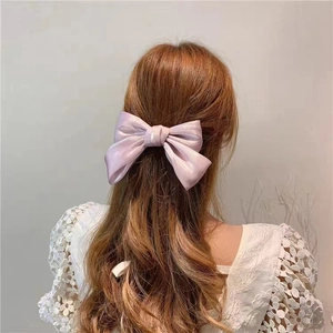 French vintage pink pearly satin bow hair clip worn by model for elegant summer look