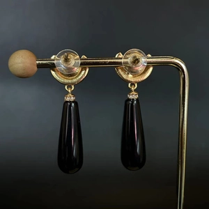 Vintage style gold earrings with black teardrop pendants and sparkling diamond accents