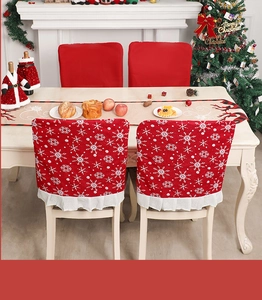 Détail de la housse de chaise de Noël en tissu rouge avec flocons et bordure à volants