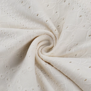 Detailaufnahme von weißem Spitzenstoff mit Stickerei und floraler Hohlraumtextur