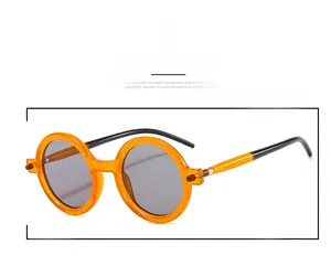 Detail of round orange acetate sunglasses with contrast temples and gray UV lenses
