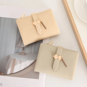 Detailaufnahme der kompakten PU-Ledergeldbörsen in Beige und Oliv mit goldener Schnalle