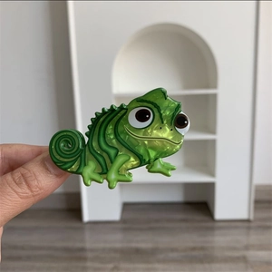 Detailed close-up of a green chameleon hair claw clip with a pearlescent acrylic finish