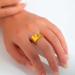 Detail of 18k gold plated wide band stainless steel ring with irregular wavy edges