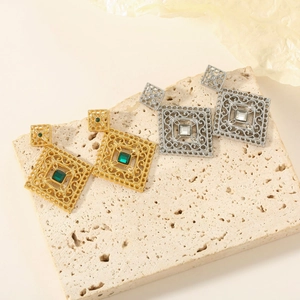 Detailed view of hollow vintage square earrings with green and clear gemstones
