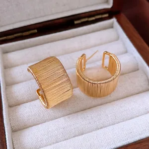18k gold plated C-shape earrings with intricate wrapped wire texture in a premium jewelry box