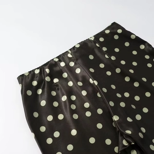 Detail des elastischen Bundes der schwarzen Polka-Dot-Satinhose mit Seidentextur