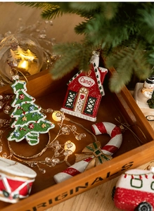 Detailed close-up of resin candy house and Christmas tree pendants in a festive tray