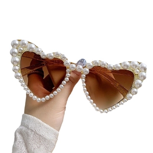 Fashionable heart-shaped sunglasses with gold frame and pearl embellishments and brown lenses