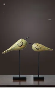 Detailed view of Nordic cracked wood bird figurines on metal stands for home decor