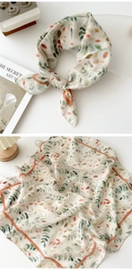 Close-up of leaf print cotton linen scarf with orange borders and soft texture