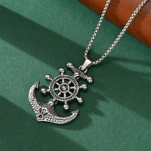 Macro view of vintage silver anchor and rudder pendant with oxidized texture and metal chain