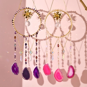 Detail of amethyst and agate suncatchers with gold floral accents on pink background