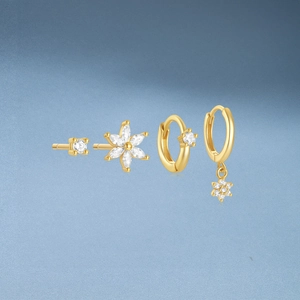 Detail view of four-piece gold plated silver earrings set with white cubic zirconia crystals