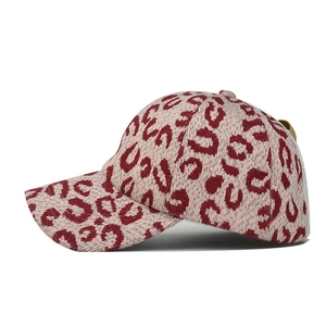 Detailed side view of thick knit baseball cap with red and beige leopard print texture