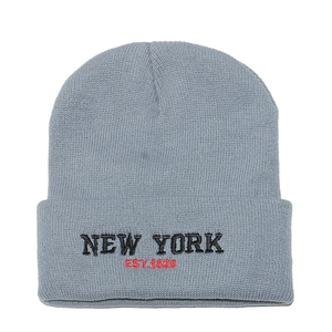 Close-up of grey knit beanie with black New York and red EST. 1625 embroidery