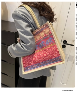 Ethnic print jute tote bag showing detailed elephant pattern and woven handle on model