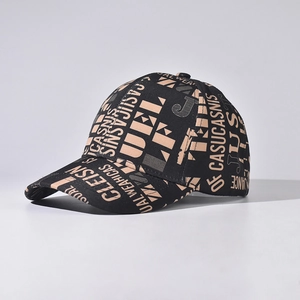 Close-up of black baseball cap featuring beige graffiti lettering and twill texture