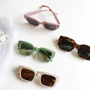 Detail view of colorful retro square sunglasses in pink, green, and tortoiseshell