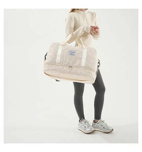 Close-up of beige quilted sports bag featuring star patterns and a separate shoe compartment