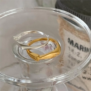 Macro shot of 925 silver brushed fish ring with gold matte texture and tiny zircon inlay