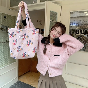Detailed texture of pink corduroy tote bag with Keep Smiling print and fleece cardigan