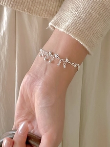 Close-up of minimalist S925 sterling silver beaded bracelet worn on a female wrist
