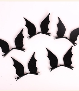 Detailed view of ten black felt bat wing hair clips for Halloween costumes on white background