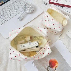 Macro view of white striped heart makeup bag showing large capacity storage with toiletries