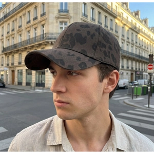 Side view of a person wearing a leopard print baseball cap in an urban street setting