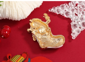 Macro detail of a gold enamel Christmas stocking brooch with red rhinestones