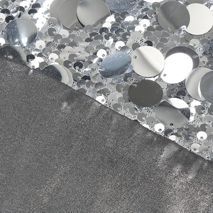 Detailed close-up of silver sequins and gray mesh fabric on a slim-fit evening dress
