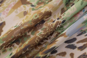 Detail shot of sheer mesh fabric with abstract camouflage print and delicate mesh texture