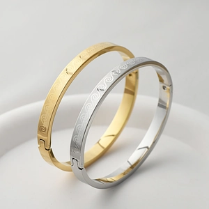 Macro detail of gold and silver titanium steel bangles with etched wave patterns