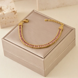 Detail of gold tennis bracelet featuring pink zircon stones and an adjustable clasp chain