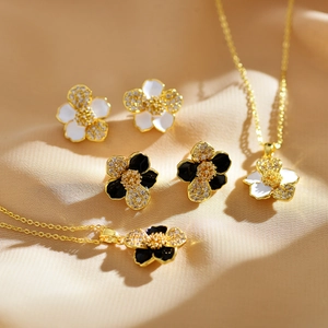 Detail of elegant gold-plated flower jewelry set with enamel and pavé crystals