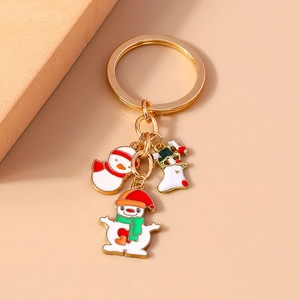 Detail of Christmas snowman and stocking charms on a gold metal keychain
