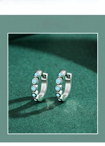 Close-up of S925 sterling silver stud earrings featuring five inset turquoise gemstones