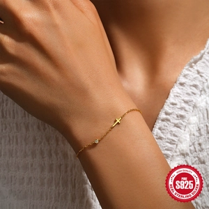 Minimalist 925 sterling silver gold plated cross bracelet with a small diamond on wrist