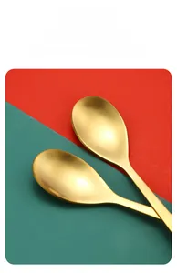 Detailed view of polished golden stainless steel dessert spoons on a festive background