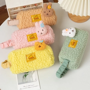 Plush lamb wool pencil pouches in four colors with cute animal ear designs on a white desk
